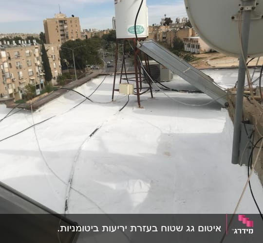 גג אטום בלבן עם דודי שמש וכבלים